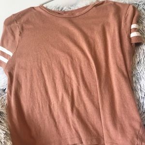 Pink shirt with two white stripes on sleeve